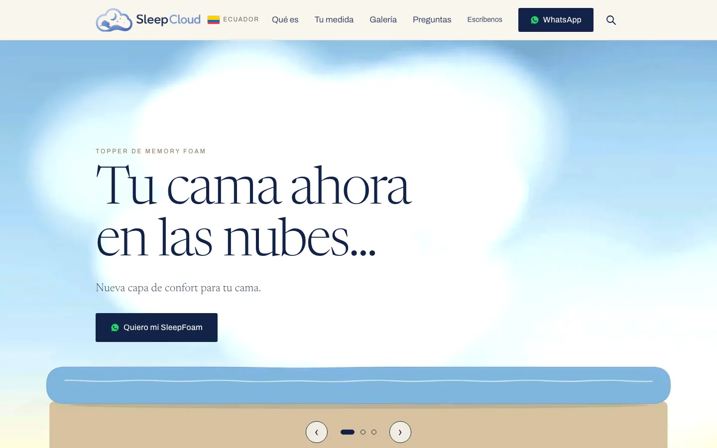 SleepCloud website home: a cloud sky over a mattress drawn with a blue topper layer, the headline Tu cama ahora en las nubes and a WhatsApp button.